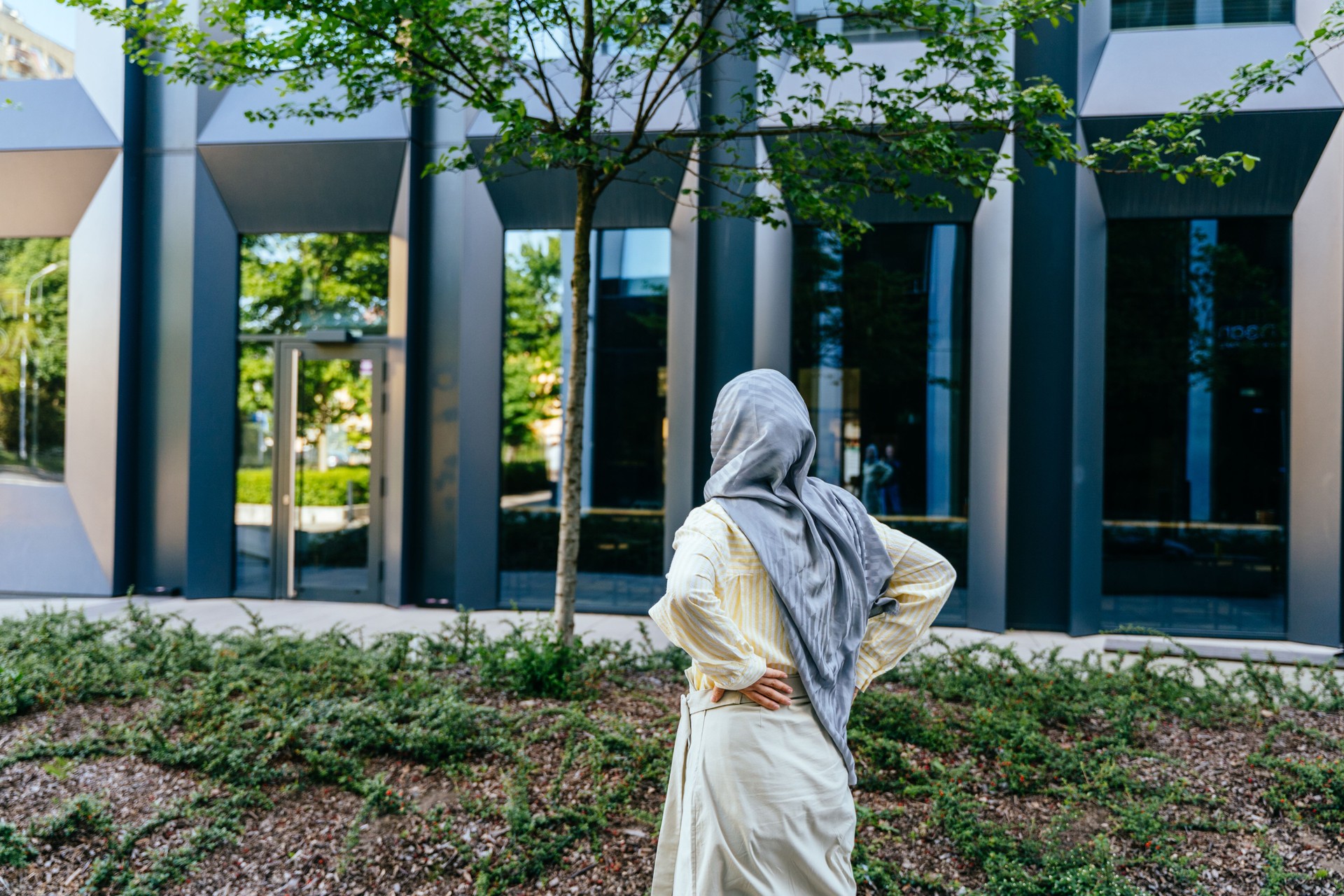 Rear View of Modern Muslim Woman Observing Futuristic Office
